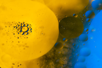 Psychedelic blueand yellow oil and water abstract background. Abstract colorful background. Foam of Soap with Bubbles macro shot. Closeup bubbles in water. Oil drops on a water surface blue and yellow