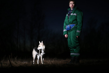Man with dog at walk on th field in sunset