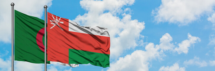 Algeria and Oman flag waving in the wind against white cloudy blue sky together. Diplomacy concept, international relations.