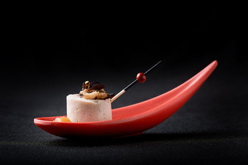 Goose liver pate, foie gras, served on black stone in Japanese red spoons. Paste served with jam and nuts. Fusion food concept, low key, copy space. © Georgii