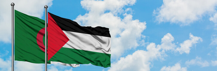 Algeria and Palestine flag waving in the wind against white cloudy blue sky together. Diplomacy...