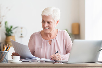 Mature editor reading printed text and making notes