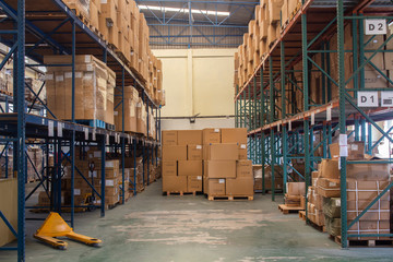 The rows of shelves with boxes in warehouse.