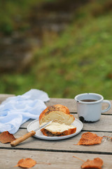 Scythe with poppy seeds, butter and tea. Baking with poppy seeds and coffee. The work of a baker. Poppy seed baking and pies.Bakery, cook together. Bun with butter on the nature in the forest. Picnic