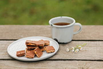 Scythe with poppy seeds, butter and tea. Baking with poppy seeds and coffee. The work of a baker. Poppy seed baking and pies.Bakery, cook together. Bun with butter on the nature in the forest. Picnic