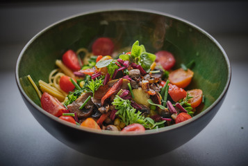 Healthy pasta salad in a green bowl