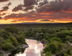 El ocaso sobre la laguna en el rio Cosquín en Córdoba