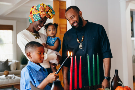 Boy lights candle to celebrate Kwanzaa