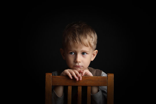 little blond boy 3-4 years old with sincere emotion. Background shot in studio with soft lights with an interesting expression and dramatic.