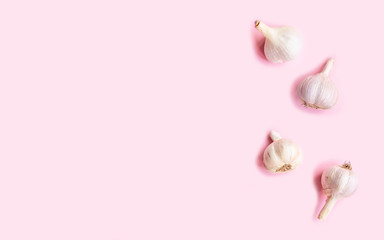 Flat lay composition with garlic on light pink background