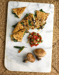 spinach and mushroom quesadilla on marble platter