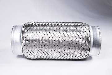 Full-contrast image flexible connection to the exhaust system of a passenger car on a gray gradient background. The concept of new car parts