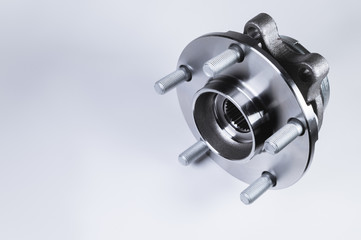 New Wheel hub assembly with bearing. This is part of the car suspension on a gray background with a gradient. The concept of new car parts