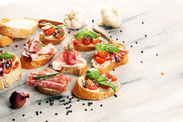 Assorted bruschetta with various toppings. Appetizing bruschetta or crudo crostini. Variety of small sandwiches. Mix bruschetta on table