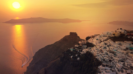 Aerial drone photo of beautiful sunset over picturesque village of Imerovigli and Skaros rock with beautiful golden colours, Santorini island, Cyclades, Greece