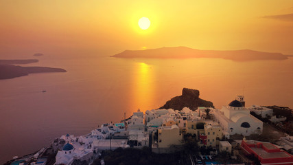 Aerial drone photo of beautiful sunset over picturesque village of Imerovigli and Skaros rock with...