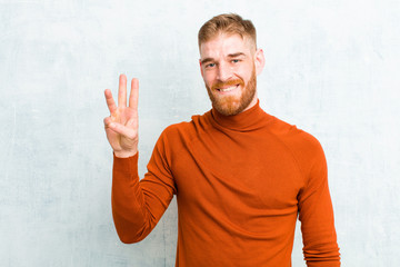 young red head man wearing turtle neck smiling and looking friendly, showing number three or third...