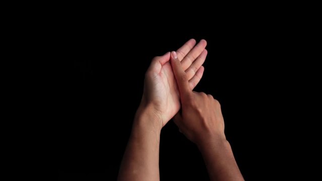 Human hands come up and show double-handed British Sign Language or BSL Alphabet L isolated against a black background. To communicate with deaf and dumb persons.