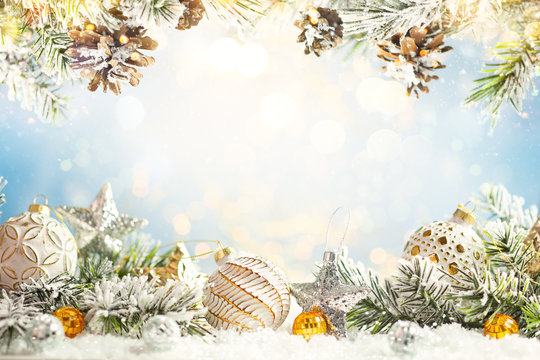 Christmas winter background with Christmas baubles and fir tree branches on snow.