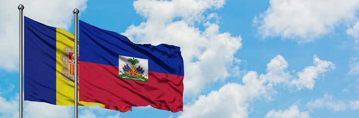 Andorra and Haiti flag waving in the wind against white cloudy blue sky together. Diplomacy concept, international relations.