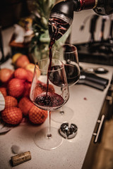 glass of red wine and bottle of wine on wooden table