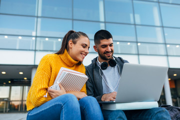 students using laptop computer outdoor in school campus