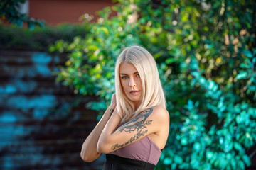 Beautiful Blond Woman in park. Summer Sunlight. Beauty blonde Girl. Make-up