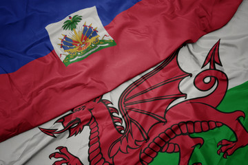 waving colorful flag of wales and national flag of haiti.