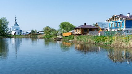 Fototapeta na wymiar Suzdal. Wooden houses on the banks of the river Kamenka.