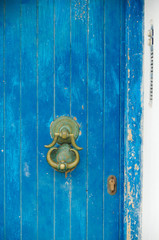Blue door in romantic backstreet alley lane alleyway street with traditional typical Greek white buildings and colorful blue white buildings and balconies on Sifnos in Greece