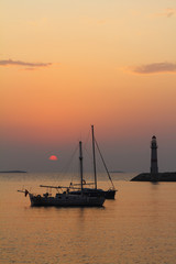 Fototapeta na wymiar Seascape at sunset. Lighthouse on the coast. Seaside town of Turgutreis and spectacular sunsets