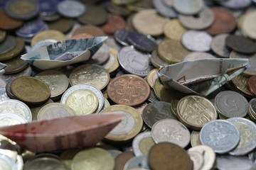 coins bills billetes de curso legal de euros hechos barquitos de papel navegando sobre monedas del...