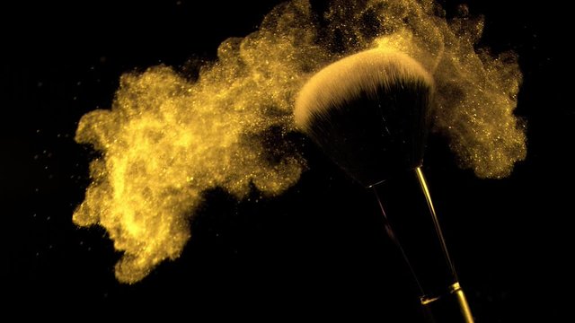 Super slow motion of makeup brush with falling powder, black background. Filmed on high speed cinema camera, 1000fps.