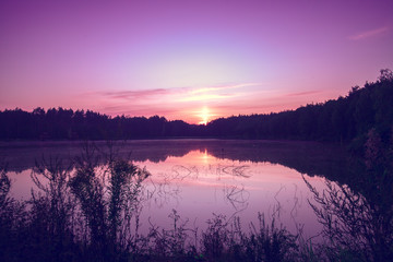 Magical sunrise over the lake with a beautiful reflection on the water. Serene lake in the early morning. Nature landscape