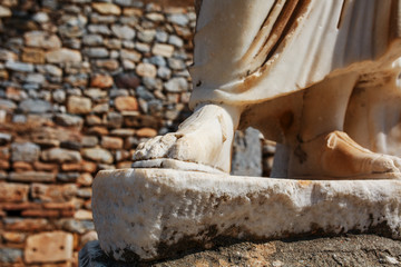 Fototapeta na wymiar Elements of marble legs of an ancient statue of the ruined city of Ephesus in Turkey.