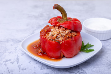 Peppers stuffed with meat, rice and vegetables with tomato sauce and sour cream. A traditional dish. Close-up.