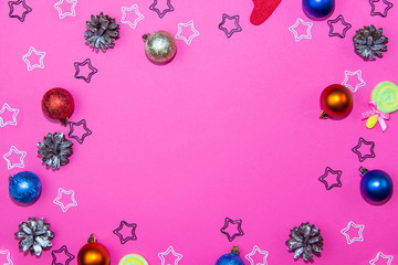 Fototapeta na wymiar Christmas decorations on a bright pink background. Christmas balls, christmas cones and stars on christmas background. Layout for recording