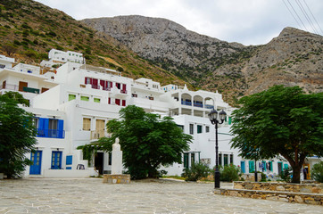 White stairs in romantic backstreet alley lane alleyway street with traditional typical Greek white buildings and colorful blue white buildings and balconies on Sifnos in Greece