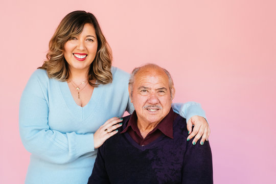 Portrait of eldery Latino grandfather with granddaughter in studio environment