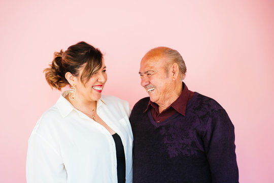 Portrait of eldery Latino grandfather with granddaughter in studio environment