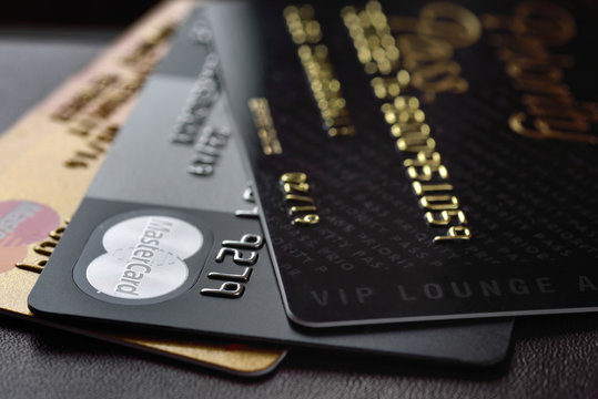RUSSIA, MOSCOW - FEB 22, 2015: Premium credit card MasterCard Black Edition, Gold Edition and Priority Pass access on the black leather background. Small depth of field
