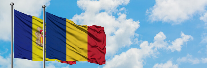 Andorra and Romania flag waving in the wind against white cloudy blue sky together. Diplomacy concept, international relations.