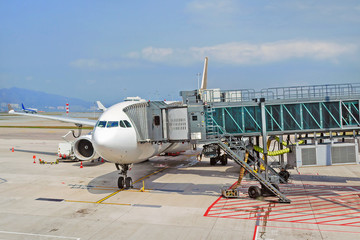 Plane with jet bridge for passengers at airport - 297368261