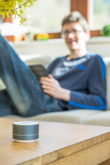 Smart ai speaker with child playing on tablet in the backround.  Smart home concept