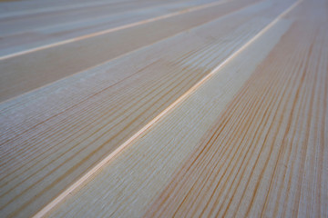 Top close up view of stack of three-layer wooden glued laminated timber beams from pine finger joint spliced boards