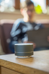 Smart ai speaker with child playing on tablet in the backround.  Smart home concept