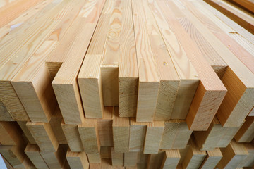 End-top close up view of stack of three-layer wooden glued laminated timber beams from pine finger joint spliced boards