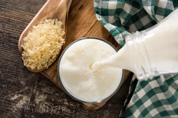 Price milk in glass on wooden table. Top view