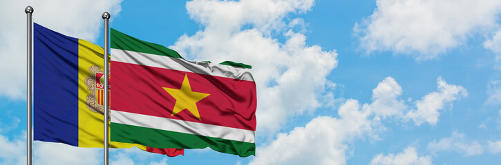 Andorra and Suriname flag waving in the wind against white cloudy blue sky together. Diplomacy concept, international relations.