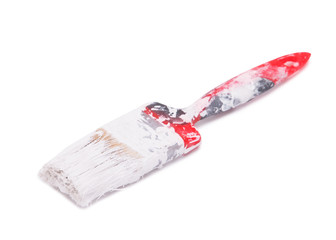 Paint brush in dried paint on a white background. Paintbrush stained with paint.